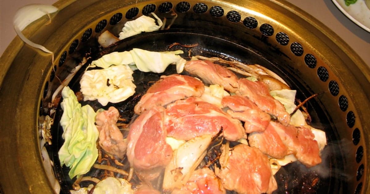 釧路のジンギスカン店でジンギスカン鍋の上で焼かれる新鮮な道産ラム肉